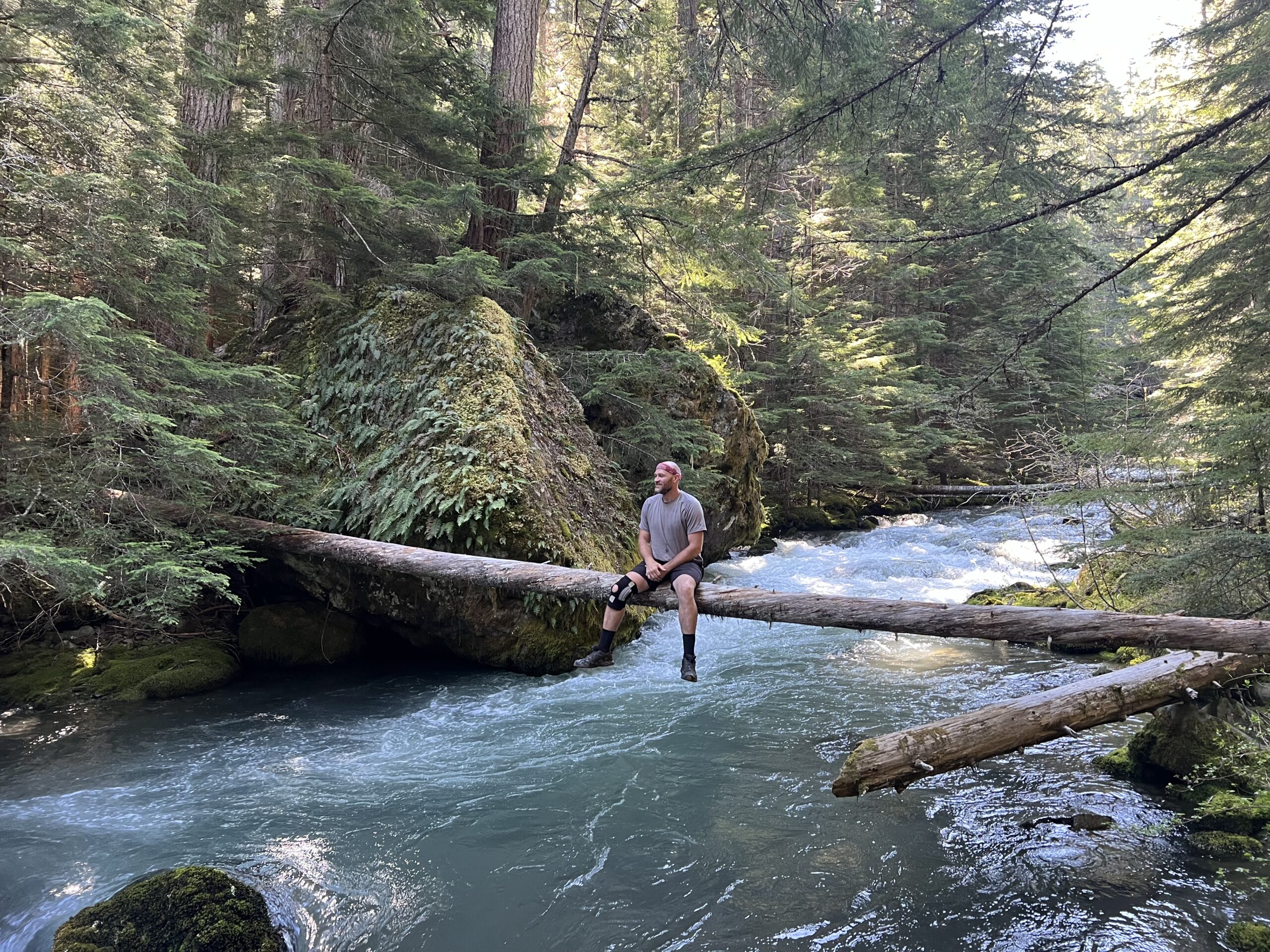 Austin Iles sitting above the raging Dungeness River in Olympic National Forest.